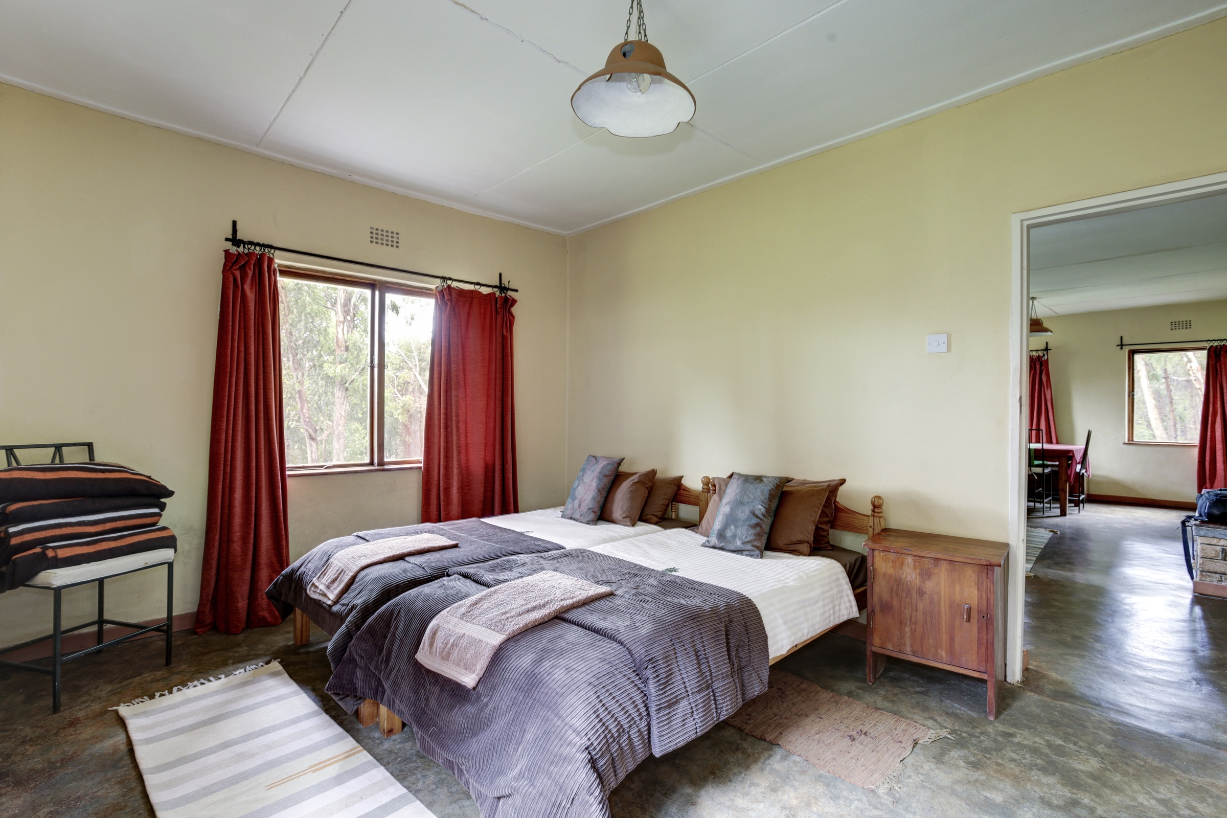 A double bed and windows in a Chelinda Camp room.