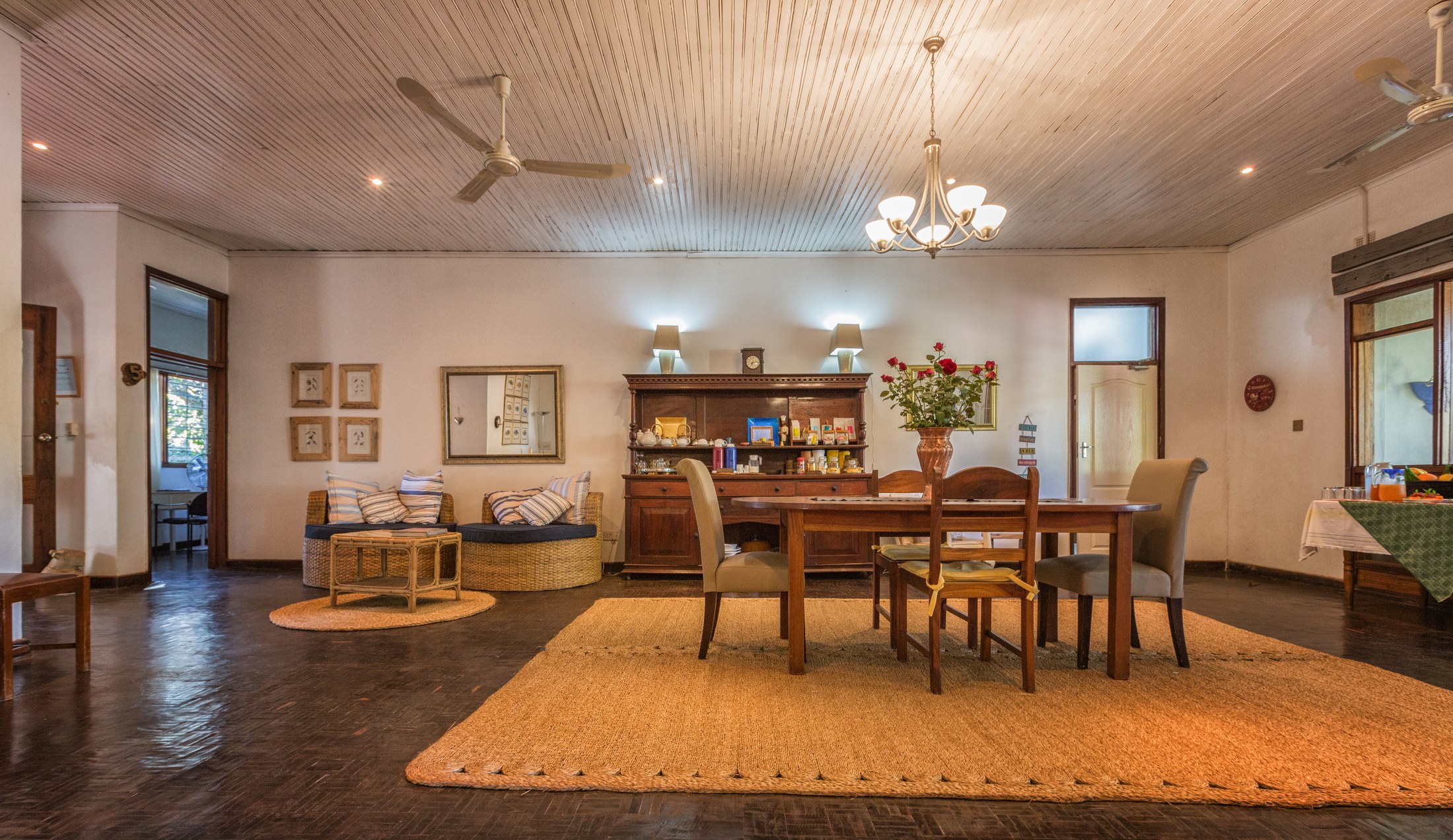 The dining area at Heuglin’s Lodge, with a wooden dining table, rugs and a ceiling fan.