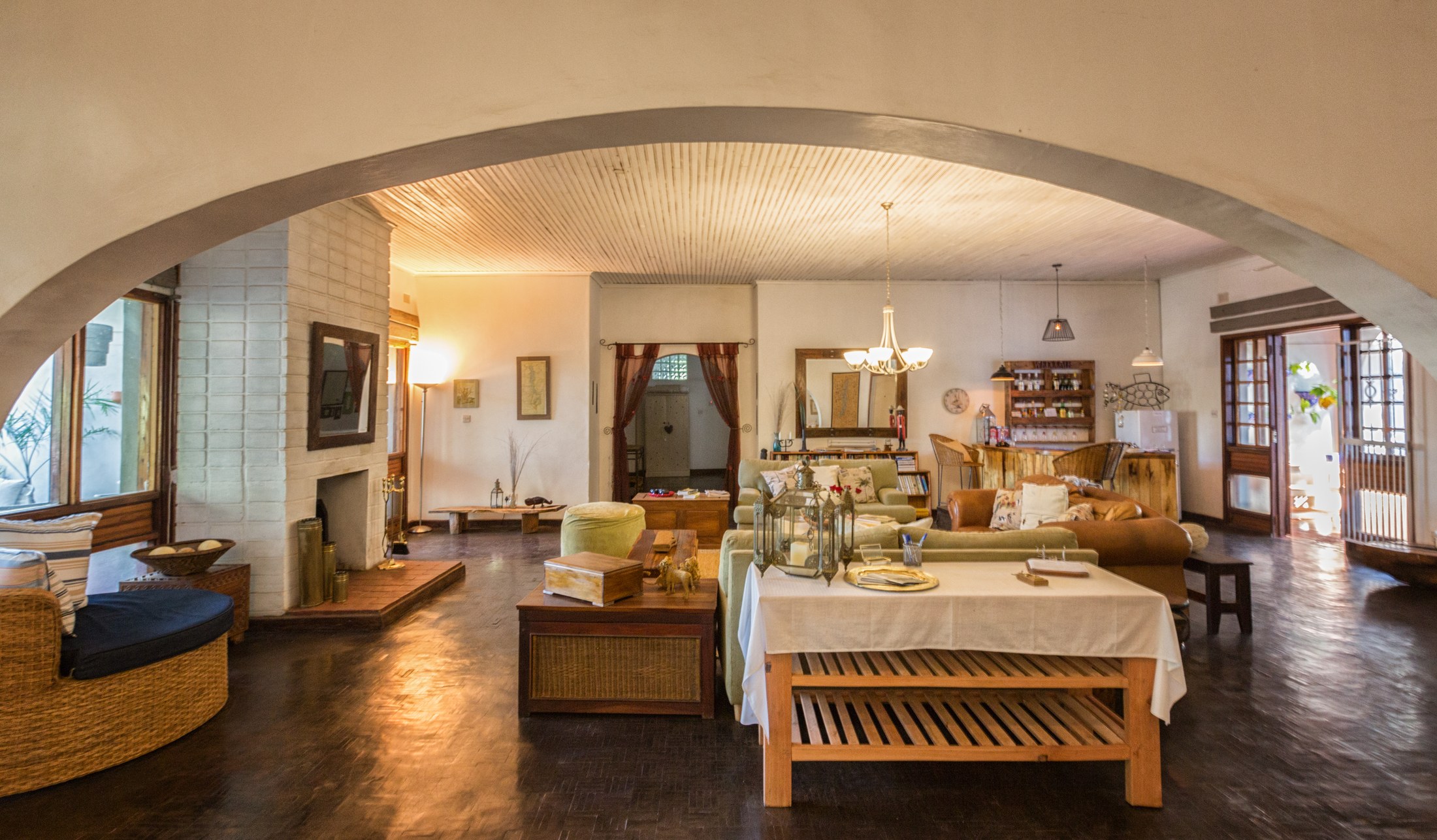 The lounge at Heuglin’s Lodge, with comfortable seating and an archway between the guest areas.