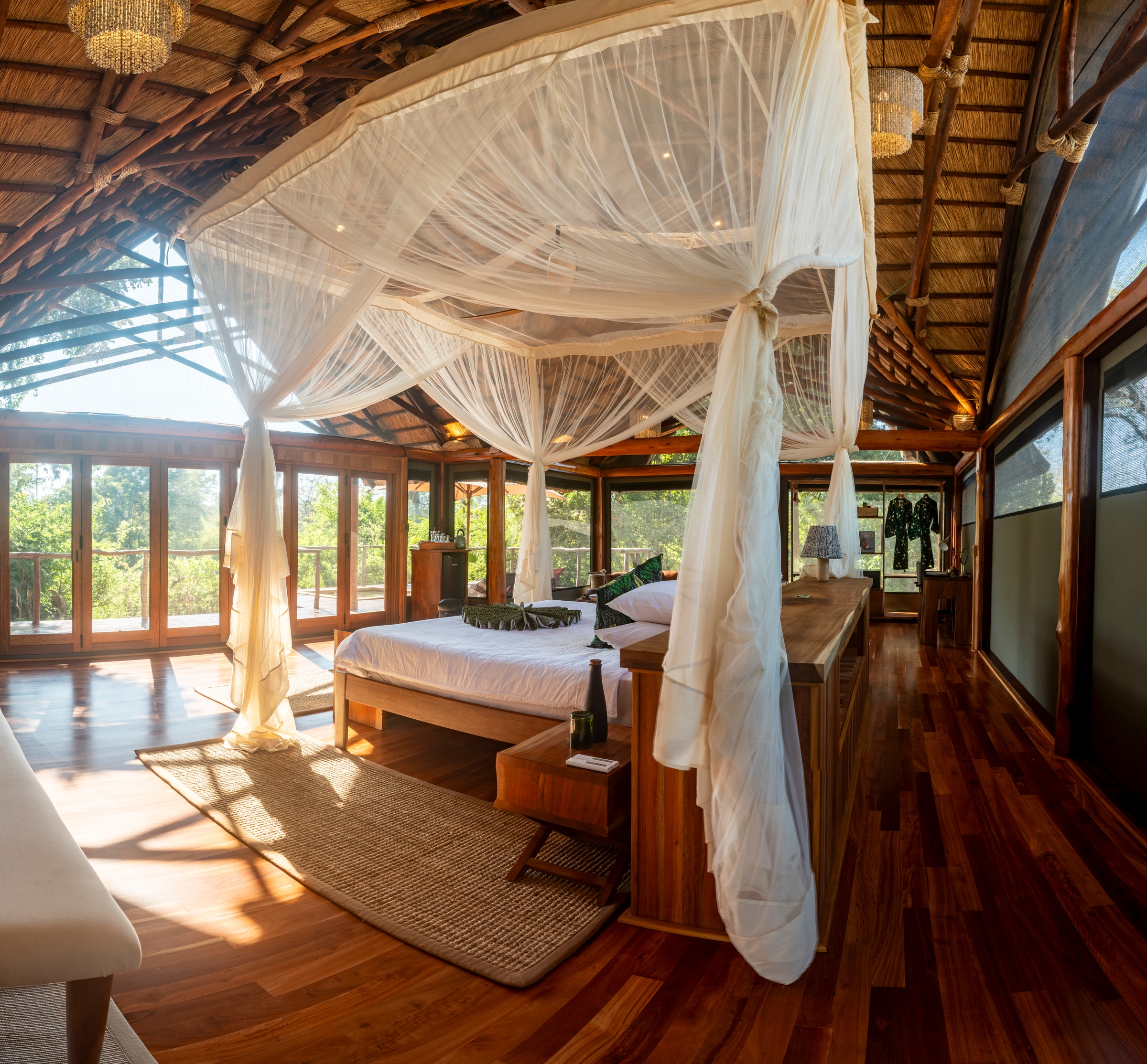 A bed beneath mosquito netting in the sunlit interior of Kuwala at Mvuu Lodge.