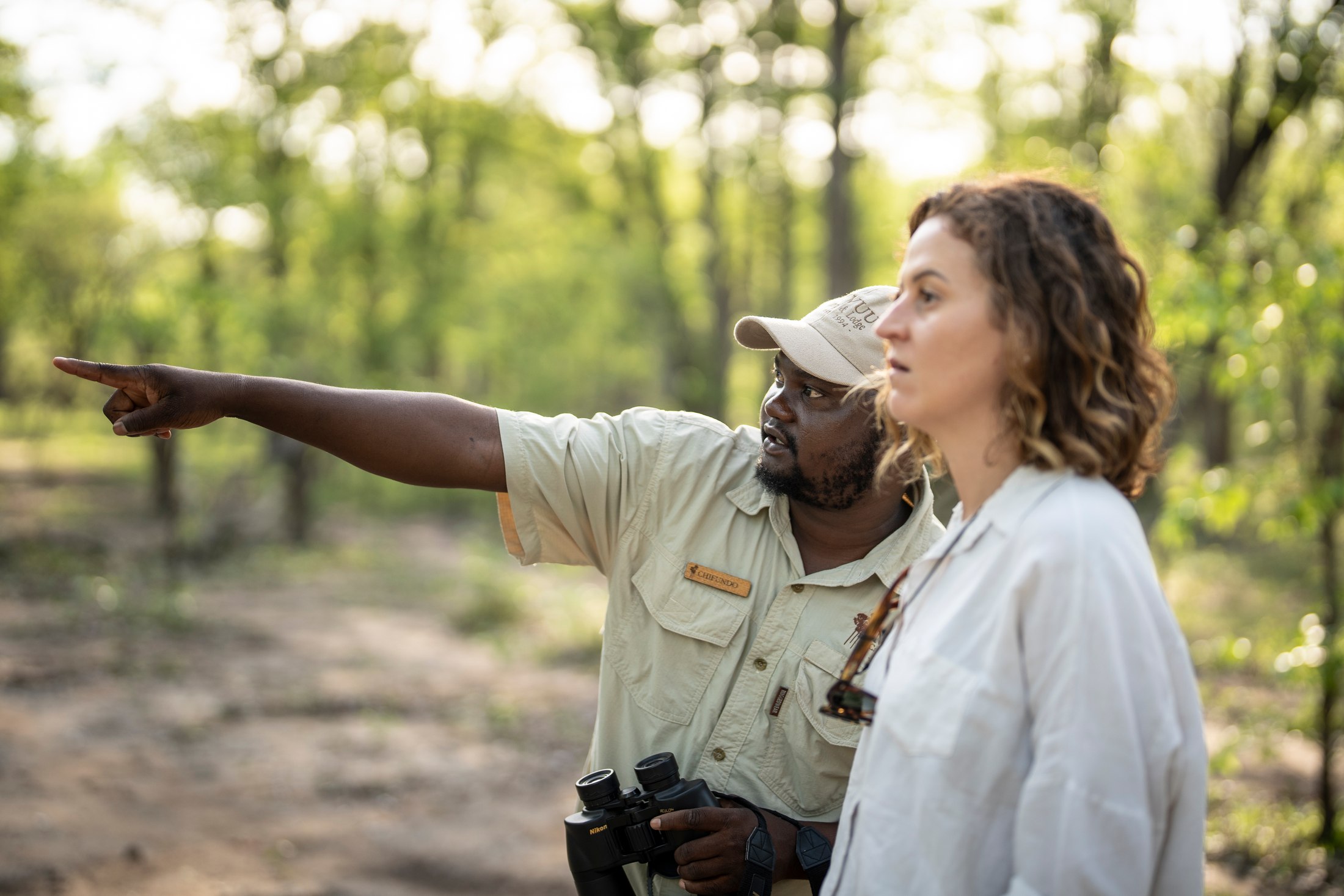 Chifundo pointing out a discovery to a guest during a walk.