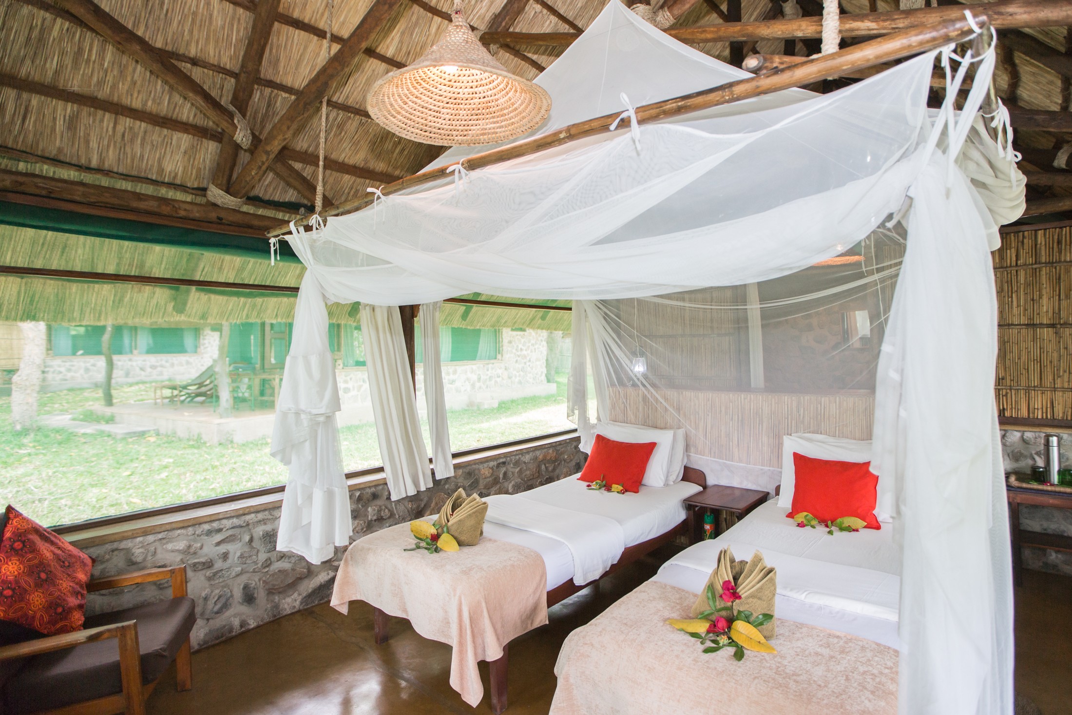 Twin beds in a thatched Mvuu Camp chalet · Juliet Lemon.